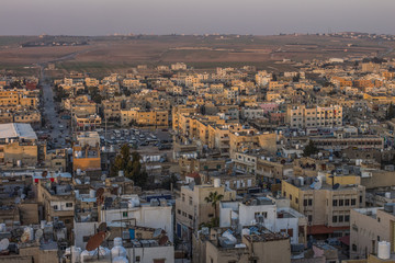 aerial photography of Arabic poor third world city in Middle East part of Earth in evening sunset time with soft colors and small stone buildings   