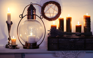 Old lamp, burning candles and lavender bunch with pentagram on wall. Magic gothic ritual. Wicca,...