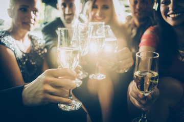Party crowd clinking glasses with champagne