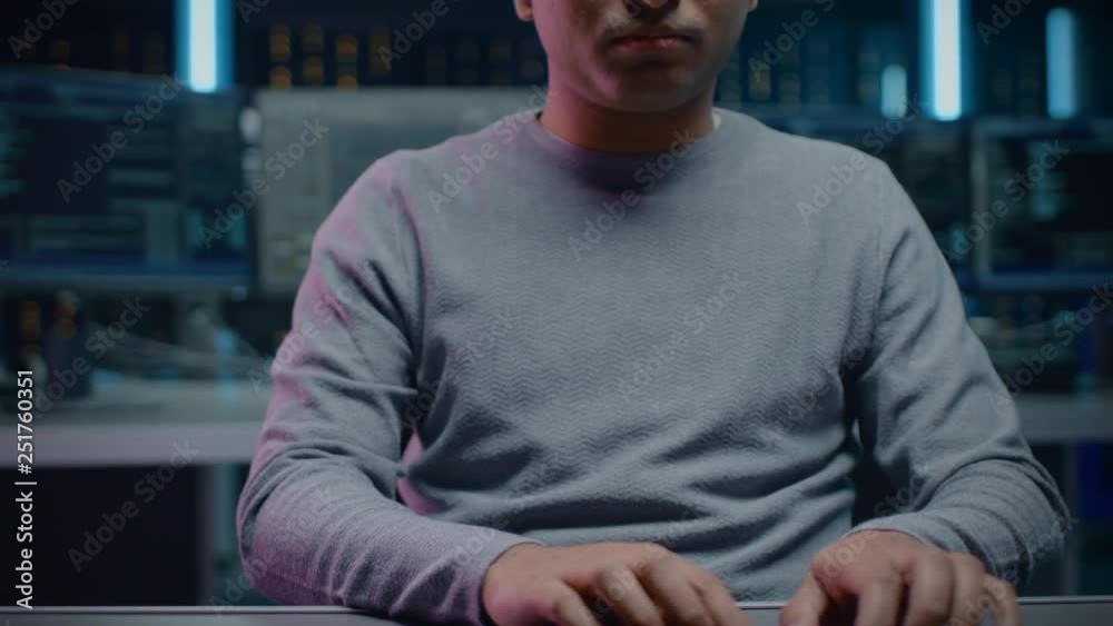 Poster Portrait of Software Developer Sitting at His Desk and Working on Computer in Digital Identity Cyber Security Data Center. Hacking or Programming. POV Camera Shot