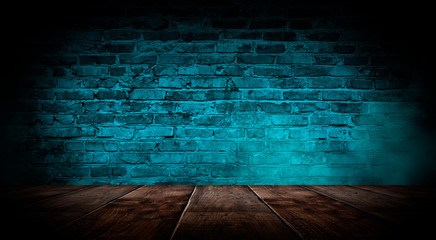 Dark empty room with brick walls and neon lights, smoke, rays. Brick wall, concrete and wooden table.