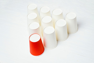 Team leader concept. Red paper glass among white. Top view.