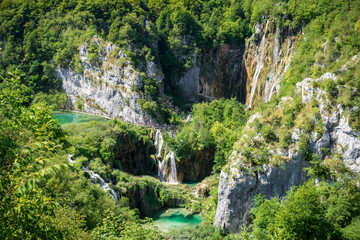 Small lakes and waterfalls in Plitvice National Park, Croatia. Beautiful view over the lakes and waterfalls surrounded by rocks and trees.