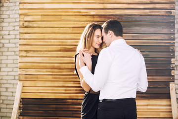 Young adult beautiful couple man and woman happy together on wooden wall background