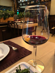 a glass of red wine on a table in a restaurant