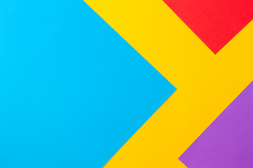 Color papers geometry flat composition background with yellow red blue and purple tones