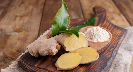 fresh ginger with leaves on wooden background. Food for health and beauty. Free space for text. Copy space.