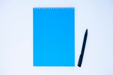 Notebook and pen on the white background. Top view, flat lay, space for a text. Education and lifestyle concept.