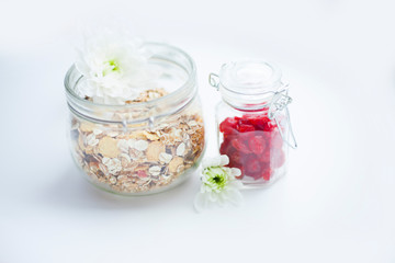 Muesli, honey and berries on the white background. Delicious and healthy breakfast. Space for a text. Top view.