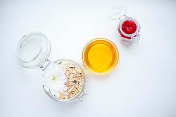 Muesli, honey and berries on the white background. Delicious and healthy breakfast. Space for a text. Top view.