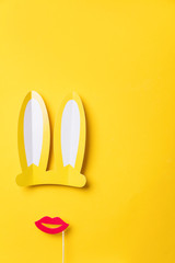 Easter bunny ears and red lips on yellow. Minimal lay flat design