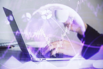 Hands typing on laptop. Business and Financial concept. Double exposure of stock market charts.