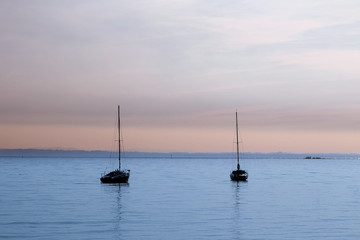 Two sailboat during the sunshine at Garda Lake. Lago di Garda, Italy. October 2018