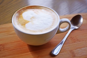 Fragrant coffee in a white Cup on a wooden background.