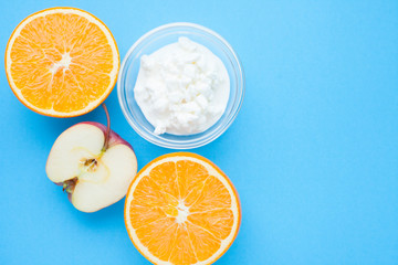 Healthy food concept. Fruits and curd on the blue background. Top view. Space for a text.