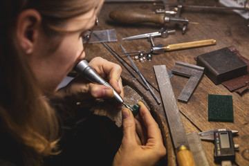 Craftwoman working on a jewel cast with a driller