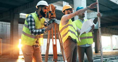 Portrait of construction engineers working on building site - obrazy, fototapety, plakaty