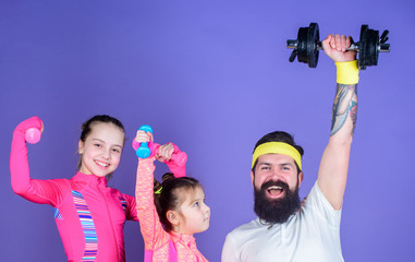 Lets practice. Sports coach and little girls building strength with dumbbells. Father and daughters exercising in gym class. Happy family training in gym class. Father and children having gym workout