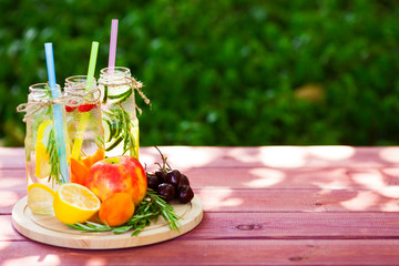 Fresh detox juices in glass bottles on the wooden background. Fruits and berries. Lifestyle, vegan food and drink, health care, diet and summer concept. Top view. Close up.