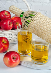 Apple juice in glasses and apples.