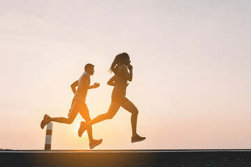 young couple runner running on running road in city park