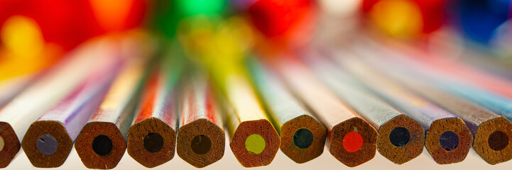 colored pencils lie on the surface of the table and blurred background.