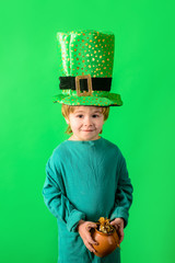 Patrick's Day. Green top hat. Little boy in green hat holds pot with gold. Leprechaun. Coin. Money....