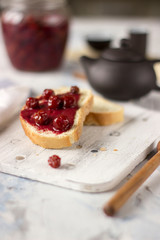 Bread with homemade cherry jam on a light background, closeup