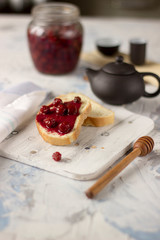 Bread with homemade cherry jam on a light background, closeup