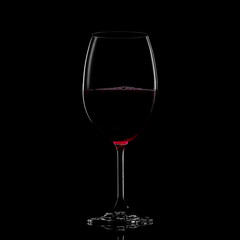 Glass of red wine on black background. Concept studio shot.