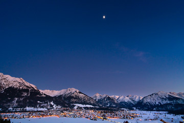 The valley Kleinwalsertal and Oberstdorf, Germany, with Alps in the winter with snow covered landscape at night.