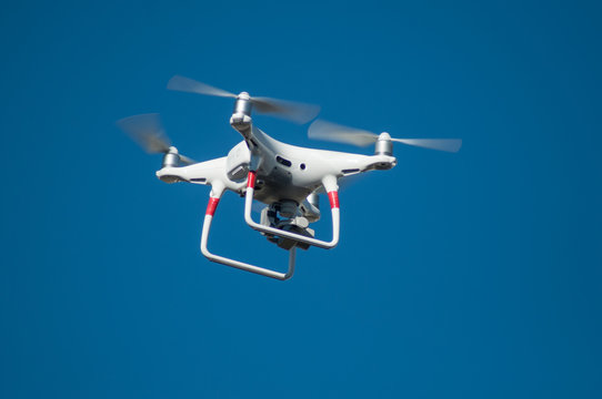 closeup of white quadcopter drone for video appllcation in outdoor on blue sky background