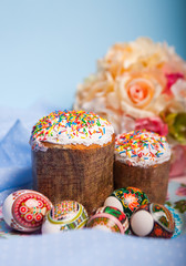Easter cakes with icing sugar and colorful painted egg on table. Traditional Easter treats of Russia and Ukraine for Orthodox Easter. Bright Easter composition