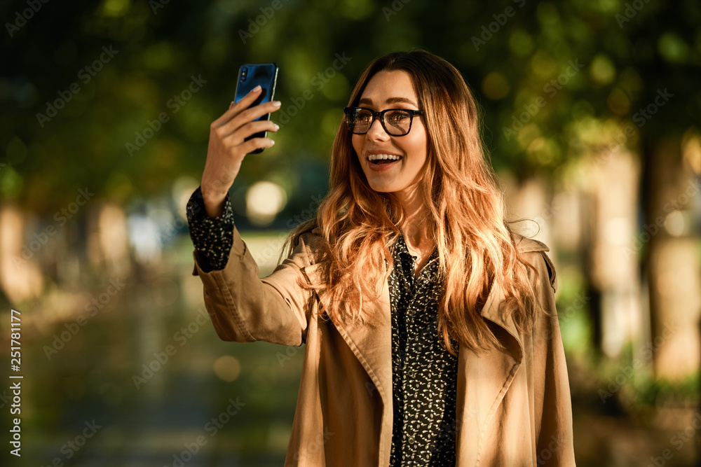 Poster portrait of businesswoman using cell phone while walking through empty boulevard