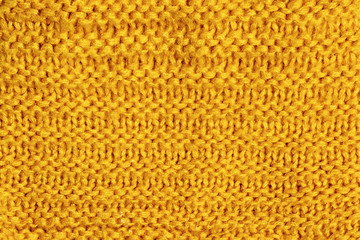Texture, bright yellow knitted jersey close-up. Blank wool background.