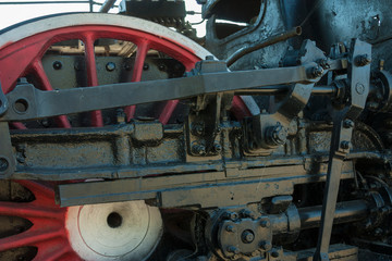 large steel wheels of old steam locomotive red with white outline