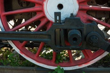 large steel wheels of old steam locomotive red with white outline