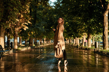 Portrait of seductive woman using mobile phone while walking through empty boulevard