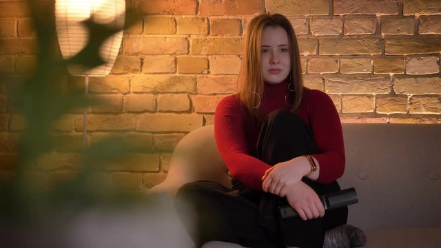 Closeup shoot of young pretty caucasian female watching a movie on TV being touched and crying