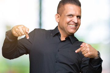 Handsome middle age arab business man over isolated background looking confident with smile on face, pointing oneself with fingers proud and happy.