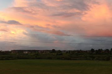 Naklejka na ściany i meble sunset clouds over the field