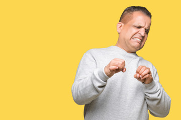 Middle age arab man wearing sport sweatshirt over isolated background disgusted expression, displeased and fearful doing disgust face because aversion reaction. With hands raised. Annoying concept.