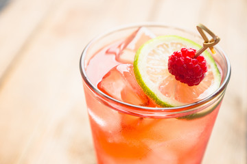 Sweet raspberry cocktail with lime slice. Selective focus. Shallow depth of field. 