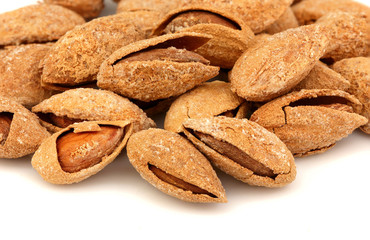 Heap of almonds in a shell with salt.