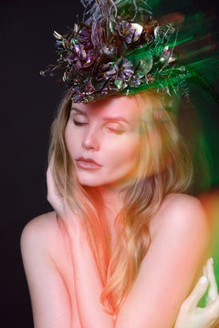 Pretty young woman in headwear with feathers and flowers