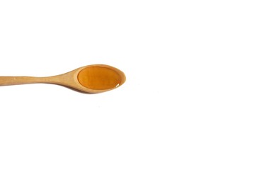 Organic honey in a wooden teaspoon on white isolated background 