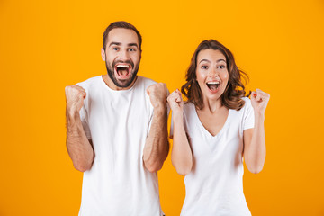 Image of ecstatic people man and woman in basic clothing laughing, while standing together isolated...