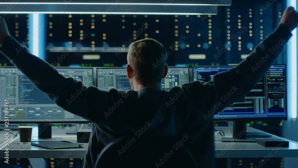 Leinwandbilder IT Specialist Working on Personal Computer with Monitors Showing Coding Language Program, He Celebrates His Success by Doing YES Gesture. Technical Room of Data Center. Back to the Camera Shot