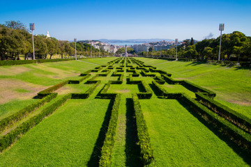 View of the labyrinth of Eduardo VII park and gardens, the largest park in the center of Lisbon and Tagus river in the background, in Lisbon, Portugal