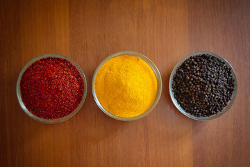 Turmeric, black pepper, red pepper and bay leaf on the table
